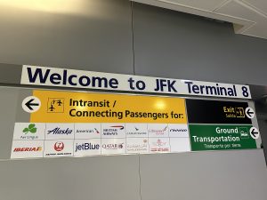 Airpot signage that says "Welcome to JFK Terminal 8"
