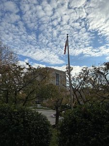 Bridgeport University with the USA Flag and fluffy clouds