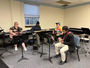 Four Bridgeport University Students playing guitars 
