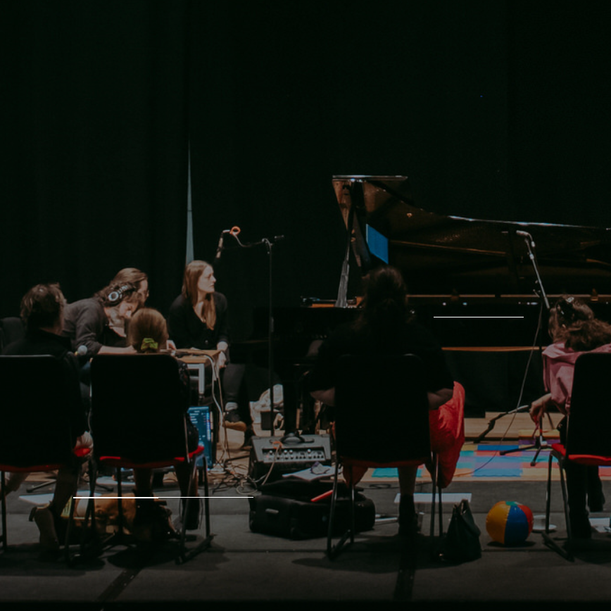 Siwan Rhys at the piano, with all Beyond Borders Beyond Barriers composers present