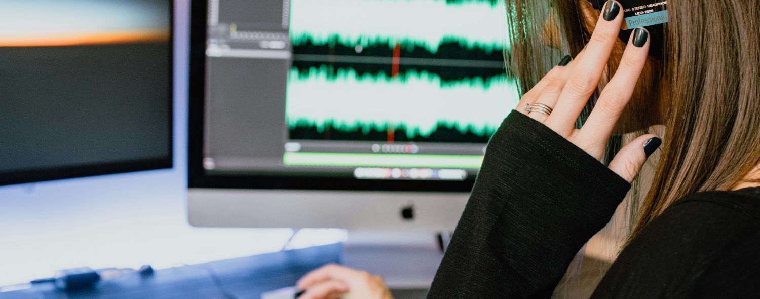 A Stock Image of a person editing audio on a Mac